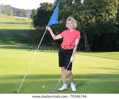 Woman playing golf/Mature Woman Golfing/Early evening round of golf