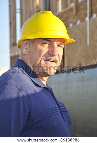 Man at a construction site/Mature construction worker/Man with hard hat working at a construction site