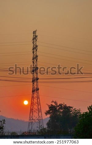 A pillar of high voltage in dim light with sun down.
