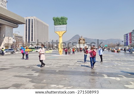 SEOUL, KOREA - MARCH 22, 2015: Tourists at Gwanghwamun Square, a human-centered space that harmonizes with the beautiful scenery of Gyeongbokgung Palace and Bukaksan Mountain in Seoul, Korea.