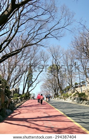 SEOUL, SOUTH KOREA - 25  MARCH , 2015: People walking along lane in Namsan park . This park is considered Seoul\'s principal park and on average welcomes 23,000 visitors every day.