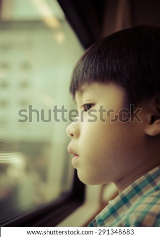 Portrait of asia boy looking out the window / Looking to the future. Soft and selective focus / Portrait of asia boy looking out the window (boy, asia, education)