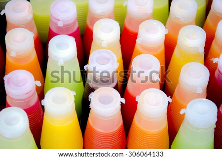 Assortment of cold tropical fruit juice in bottles/ Bottle of juice view from above