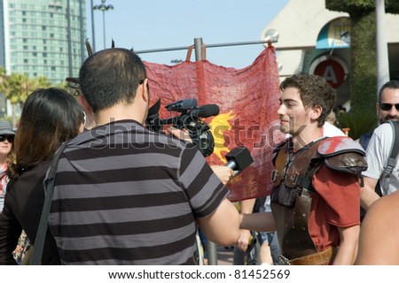SAN DIEGO - JULY 21:  Man in Roman costume and interviewers at Comic Con International in downtown in San Diego, CA on July 21, 2011.