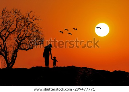 Mother and baby silhouette. Sunset and birds flying
