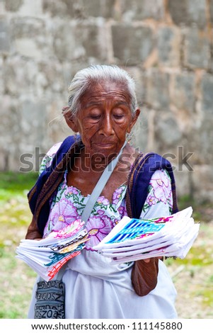 CHICHEN ITZA, MEXICO - AUGUST 15: Elderly woman selling traditional mayan handkerchiefs and napkin in Chichen Itza site on August 15, 2012 in Yucatan, Mayan Riviera, Mexico