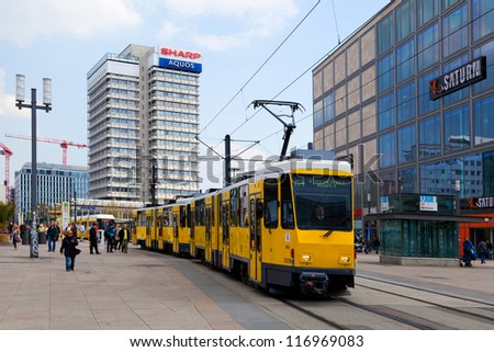 BERLIN, GERMANY - APRIL 20: People taking a yellow tram in Alexander Platz on April 20, 2012. The tram in Berlin is one of the oldest tram systems, since its origins date back to 1865.