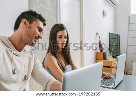 Young Couple Working at Home with Two Laptops