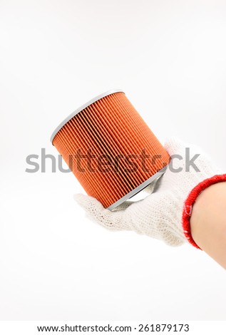 closeup of hand holding a black oil filter for an automobile