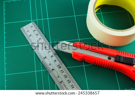 cutter ,tape and ruler on the cutting mat
