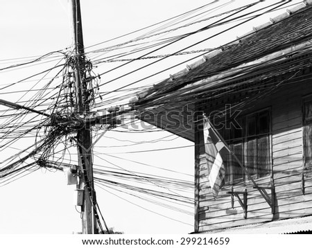 black and white electricity post , wire cable and house