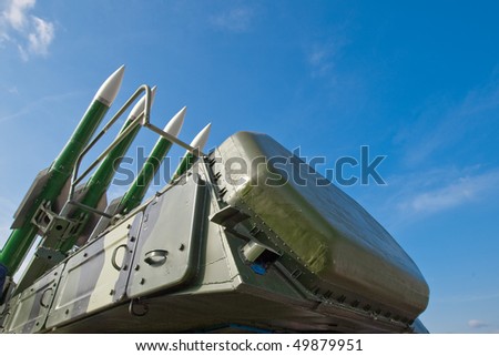 Green military rockets on transportation under blue sky
