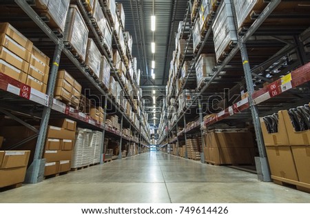 Large warehouse logistic or distribution center. Interior of warehouse with rows of shelves with big boxes  Distribution or delivery warehouse, logistics warehouse dispatch of goods