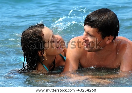 Happy young woman and man in water
