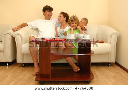 Family four together with two children sit have breakfast