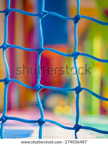 Blue net closeup in children playground. Colorful plastic background