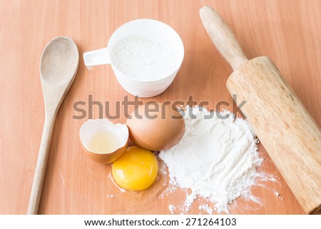 Ingredients for baking cake with egg on a wooden worktop