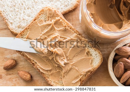 Peanut butter  with nuts on wooden table