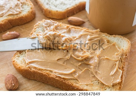 Peanut butter  with nuts on wooden table