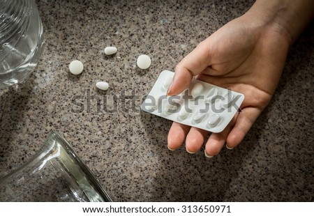Hand of a person to committed suicide with sleeping tablets