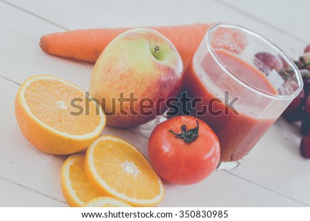 Fresh juice glass and fruits on table - healthy eating