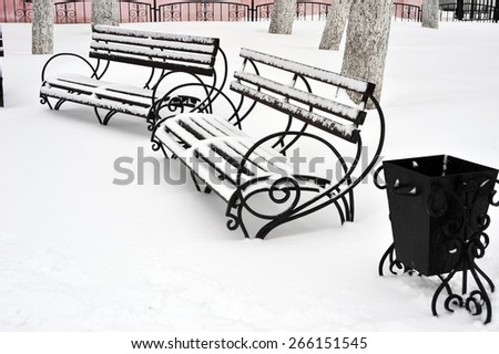 Outdoor furniture. Wood park bench with urn. Winter park with snow surface bench. Park bench isolated. Two benches in the winter park.