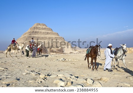 Sakaka, Egypt - January 2010: Local tour guides and tourists in the archaeological site with the stepped pyramid in the background