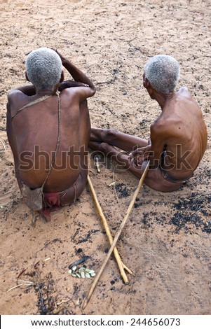 Grashoek, Namibia - December 12 2009: Owamboland, two old indigenous man seated  in the bushmen village