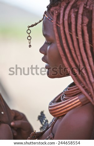 Kaokoland, Namibia - December 9 2009: The profile of a beautiful indigenous girl with body painted in a Himba village