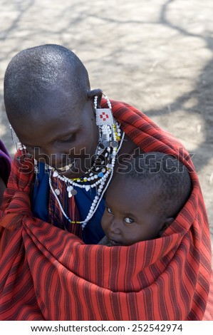 Ngorongoro, Tanzania - September 1 2008: A mother with traditional jewels and with a baby in her arms in a Masai village