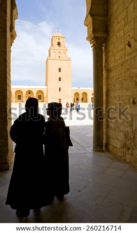 Kairouan,Tunisia - May 5 2007: Local women in back-light in the courtyard of the Sidi Oqba mosque also known as the Grand Mosque