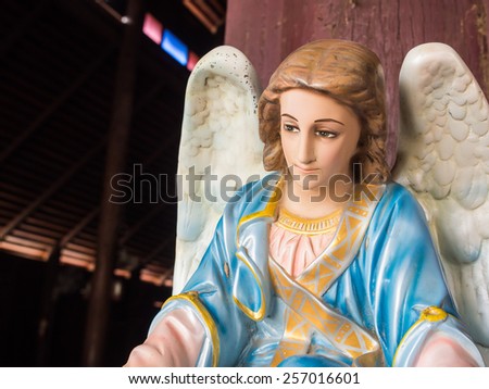 An angel with white wings at the front of wooden church