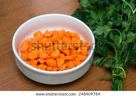 Carrots cut in a bow with a parsley bundle on a table