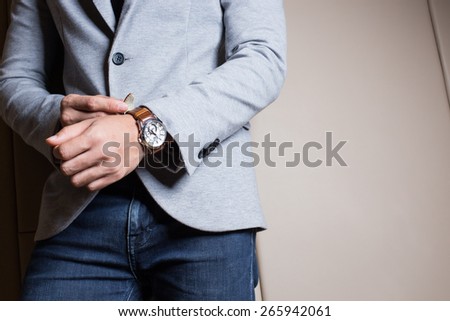Businessman in gray suite,Blue jeans. Part of body. On beige color background