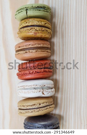 traditional french sweet dessert colorful delicious macarons in a rows in a box on wood background focus on red