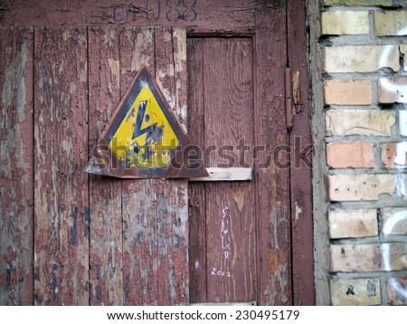 High voltage sign plate - Old wooden door - Brown peeling paint