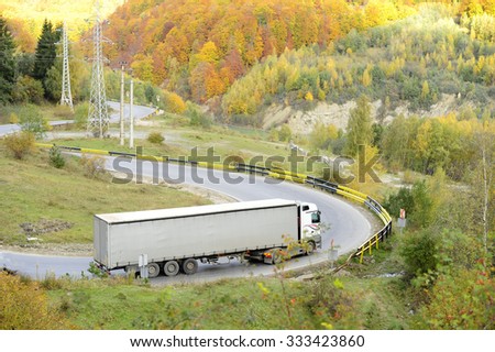 Trucks on the turning road in the mountains - autumn background