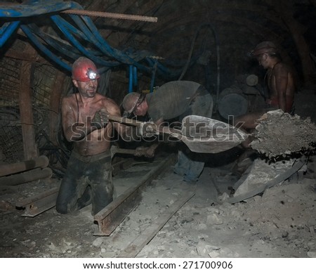Donetsk, Ukraine - August, 16, 2013: Miners perform heavy manual labor in low light conditions and dusty. Mine is named Chelyuskintsev