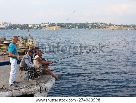 Ukraine, Sevastopol - September 04, 2011: Men go fishing in the afternoon at the city wharf