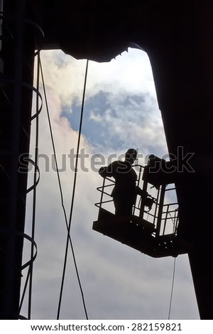 Silhouette of builder working at height. Industry