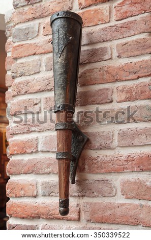 Stylized lamp in the form of the ancient torch on a brick wall. Interior