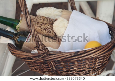 Bread, wine and lemon in a wicker basket. Food and beverages