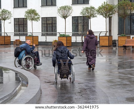 Kiev, Ukraine - October 24, 2015: Couple of people with disabilities in wheelchairs see the sights