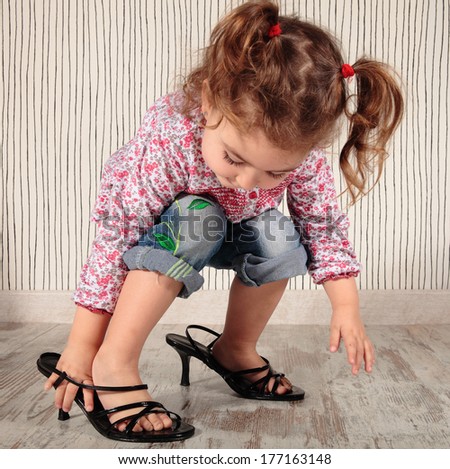a little girl with momÃ?Â´s shoes