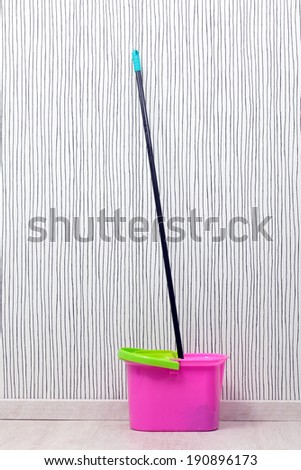 a bucket and a mop on a wooden floor