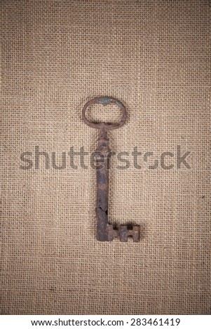 18th century antique key over a sackcloth texture