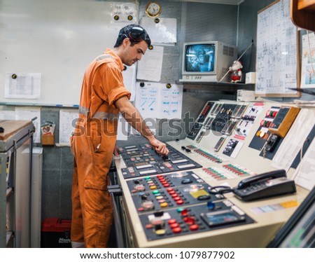 Marine engineer officer starts or stops main engine of ship in engine control room ECR. Seamen\'s work.