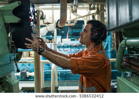 Marine engineer inspecting ship\'s engine in engine control room ECR. Seamen\'s work.