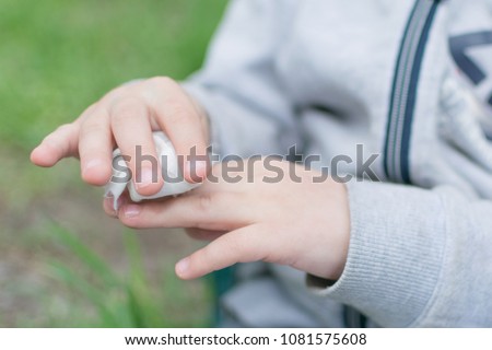 The child wipes his hands with disposable wet wipes