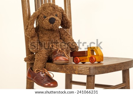 Cute Soft toy puppy sitting on a chair in old leather shoes